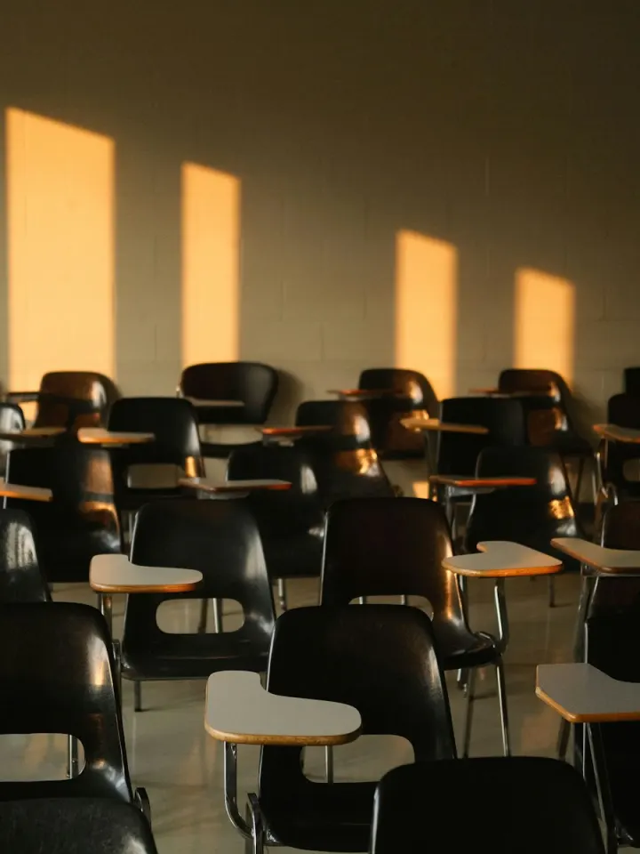 Empty classroom chairs lit by warm afternoon sun
